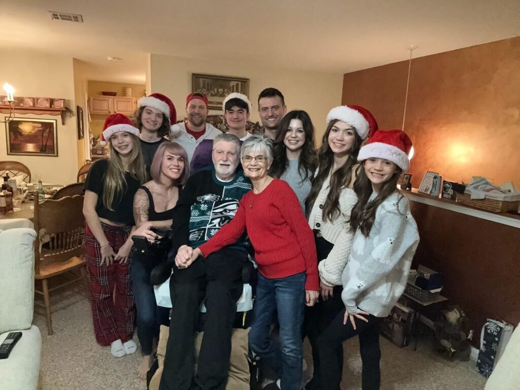 Diane and Bill surrounded by family during Christmas celebration