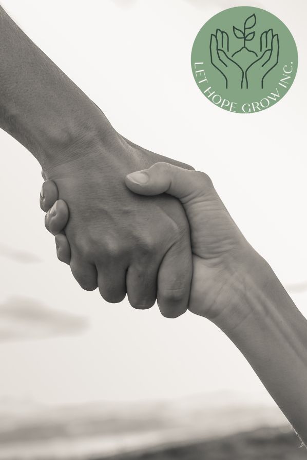 Two hands holding in support, symbolizing Let Hope Grow’s mission to walk alongside ALS families through hope, care, and compassion